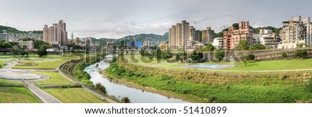 Panoramic cityscape of park with river and buildings in Taipei, Taiwan.