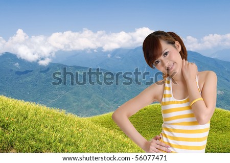 Outdoor girl in green field under blue sky with smiling expression.