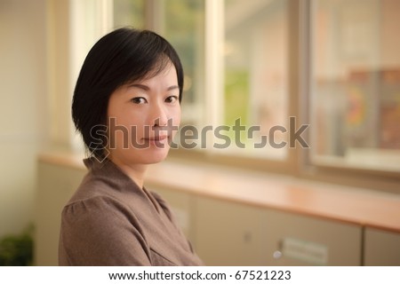 Kindly Asian woman face, closeup portrait indoor.