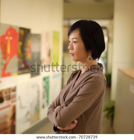 Mature Asian woman thinking, closeup portrait indoor.