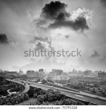 Sunset city with light beam over clouds, cityscape with highway and buildings in black and white tone in Taipei, Taiwan, Asia.
