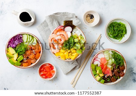 Hawaiian salmon, tuna and shrimp poke bowls with seaweed, avocado, mango, pickled ginger, sesame seeds. Top view, overhead, flat lay