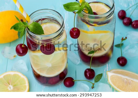 Detox fruit infused flavored water with cherry, lemon and mint. Refreshing summer homemade cocktail. Clean eating