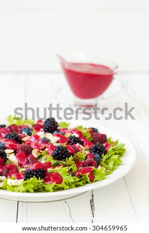 Summer refreshing mixed berry salad with pumpkin seeds, blue cheese, feta and sweet red raspberry vinaigrette. Copy space background