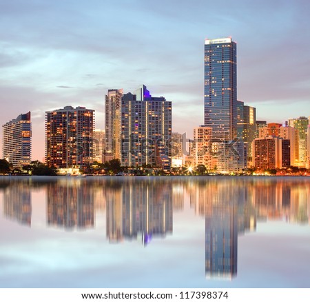 Miami Florida, cityscape of illuminated downtown buildings at sunset with reflections in the water of Biscayne Bay. Panoramic skyline of the World famous travel location