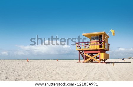 Miami Beach Florida, lifeguard house in typical colorful Art Deco style on a sunny summer day, with blue sky, and Atlantic Ocean in the background. World famous travel location.