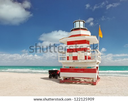 Miami Beach Florida, lifeguard house in a typical colorful Art Deco style on a bright sunny summer day, with blue sky and Atlantic Ocean in the background. World famous travel location.