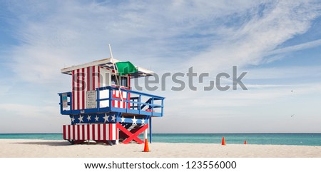 Miami Beach Florida, lifeguard house in a typical colorful Art Deco style,painted in the American flag colors on a summer day, with blue sky and Ocean in the background. Famous travel location.