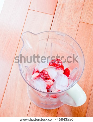 Fresh Strawberries and ice in a blender, for fruit milkshake