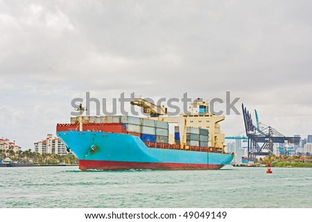 Industrial transport cargo ship loaded with containers is leaving the port