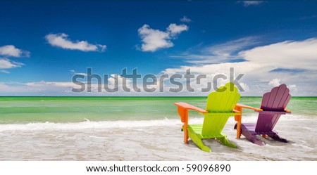 Colorful green and purple  lounge chair at the tropical beach in Miami Florida with beautiful ocean waters and blue sky.