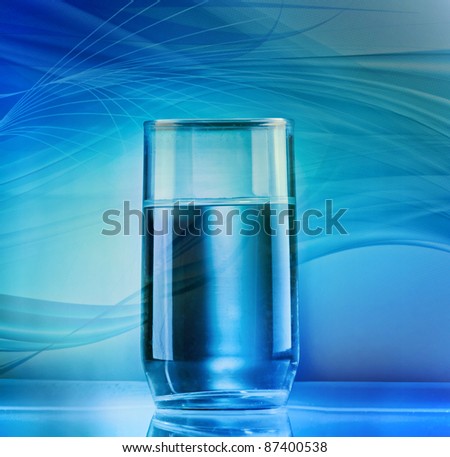 Glass of water, closeup shot on blue and green abstract background.