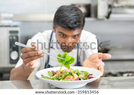 cooking, profession, cuisine, food and people concept - happy male chef cook decorating dish salad