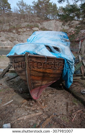 Picture of a abandoned old wooden boat covered with a rag
