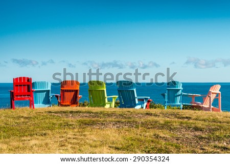7 Colorful chairs, red, green, blue, green,  by the sea. Early retirement. Vacation time. Financial freedom. Pleasant Bay, Cape Breton, Nova Scotia, Canada