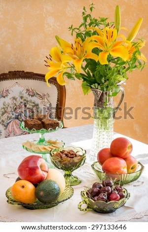Antique / retro style afternoon tea table. Fruits and nuts in green Depression glassware. Dignity and elegance from the difficult time of America in the 1930s. Tablescape.