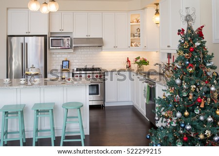 New white kitchen with Christmas decorations. Retro / antique style. Hand painted chairs with chalk paint, Christmas pattern English fine bone china teacups and plates. Decorated Christmas tree.
