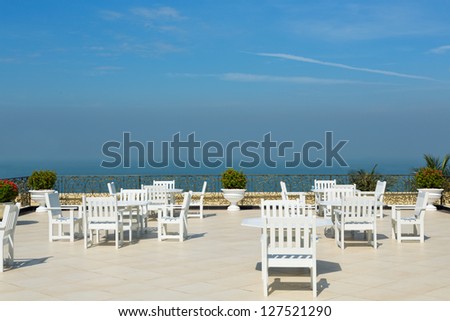 An empty rooftop restaurant with views of the sea. Sunny day.