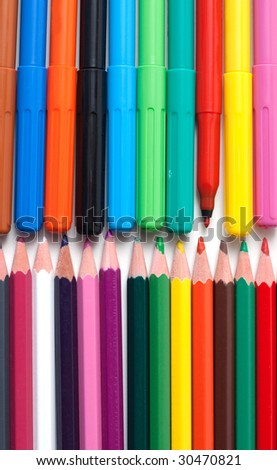 Crayons and soft-tip pens to rest upon white background