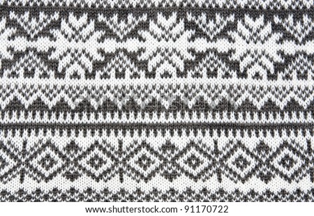 gray background with a knitted pattern to form snowflakes
