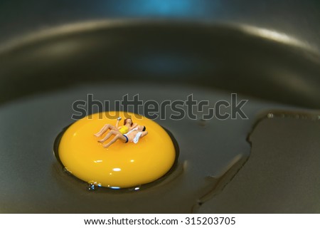Miniature people sleeping on egg