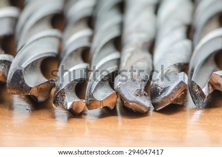 Seven drill bits on wood board