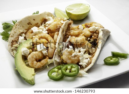 Shrimp tacos with re-fried beans,salsa and avocado using flour tortillas.