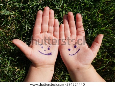 smiles painted on the children\'s palms