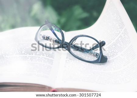 Open book with glasses on nature background. Vintage style. Knowledge is power