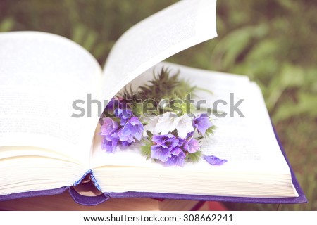 Open book on nature background. Knowledge is power. Flowers in book. Education