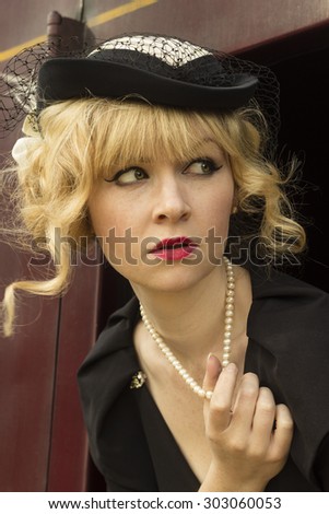 Elegant retro / vintage style woman playing with her pearl necklace