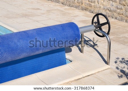 Pool cover rolled up on a roller