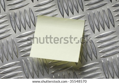 sticky note pasted on a metallic aluminum