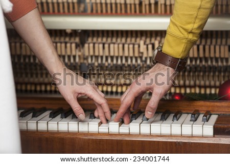 a man and a woman playing the piano together. close-up