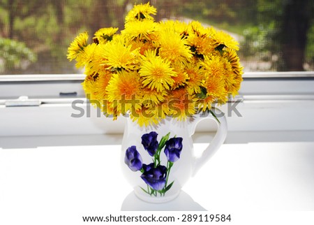 Yellow dandelions in a vase.