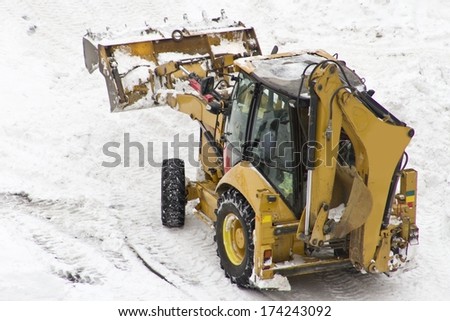 An excavator cleans snow blocked parking