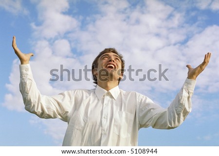 successful businessman with arms outstretched to the sky