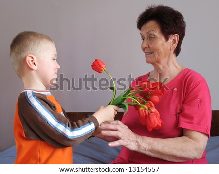 grandson present flowers to grandmother