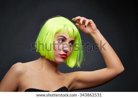 beautiful woman with black nails wearing colorful short hair wig on black background