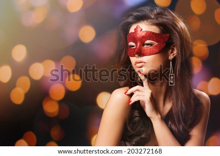 Masquerade. Beautiful Girl in a Carnival mask over Holiday Blinking Background. Bokeh