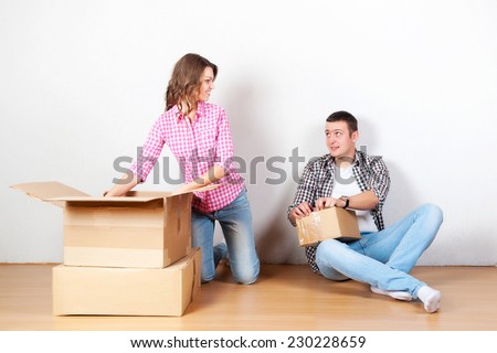 Happy couple carrying boxes at moving house. photo