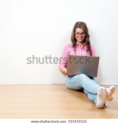 Young creative woman sitting in the floor with laptop./ Casual blogger woman