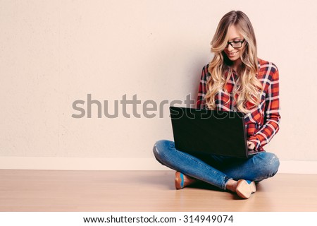 Young creative woman sitting in the floor with laptop./ Casual blogger woman