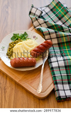 Grilled sausages and mashed potatoes with green peas
