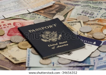 Closeup of a Passport with ticket stubs on top of mixed foreign money including US, Taiwan, Indian, Hong Kong, Honduran, Malaysian and Korean currency