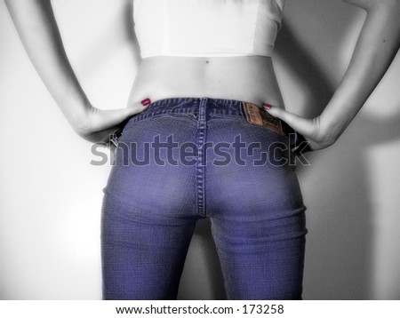 Tinted black and white of female figure in jeans, back view