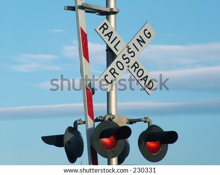 Railroad Crossing sign against blue sky with clouds