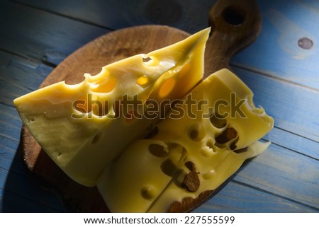 a piece of cheese on blue wooden background