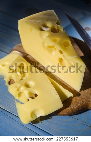 a piece of cheese on blue wooden background
