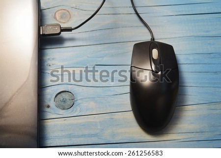 black computer mouse on wooden background